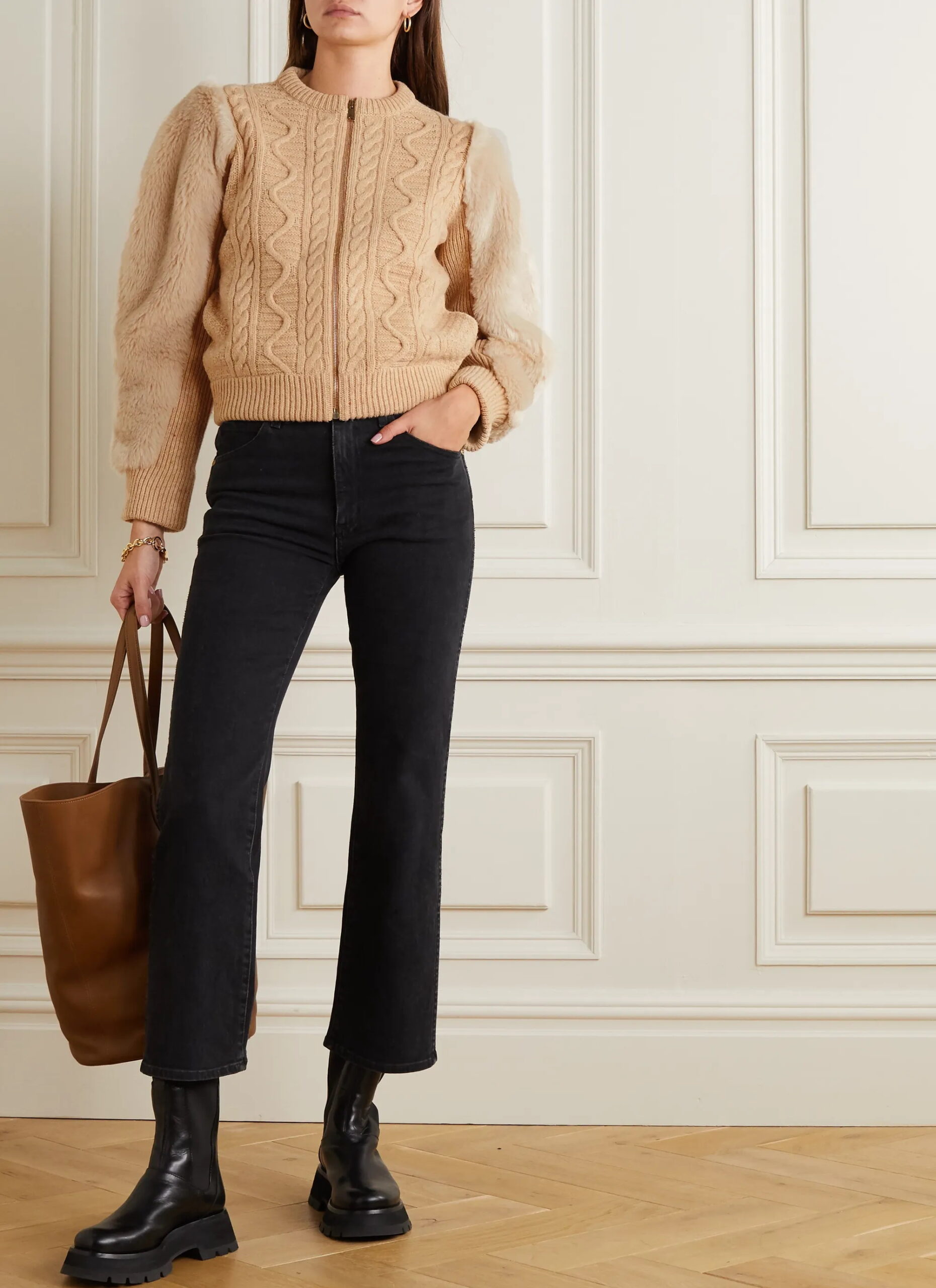 Tanara care poarta jeansi negri scurti, pulover, ghete si geanta